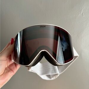 Ski/snowboard goggles. White band with pink holographic lens.